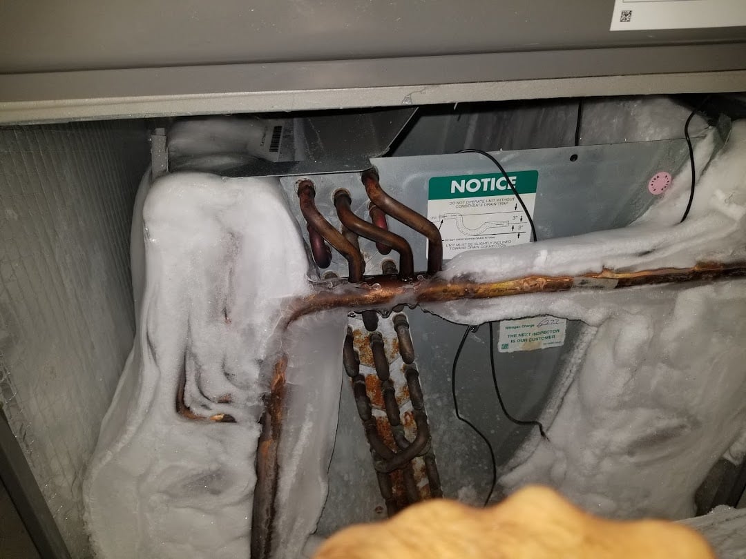 Jireh Cooler technician diagnosing a frozen evaporator coil during an AC repair call